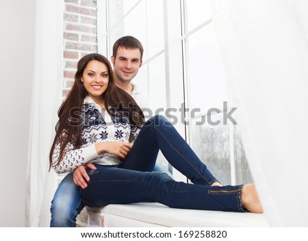 Couple in love at home relaxing on the window
