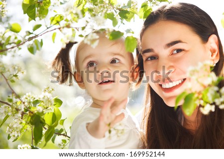 Happy mother and her little daughter in the spring day