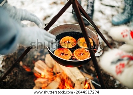 From above traditional mulled wine with slices of orange preparing in pot over burning logs in winter in countryside Сток-фото © 