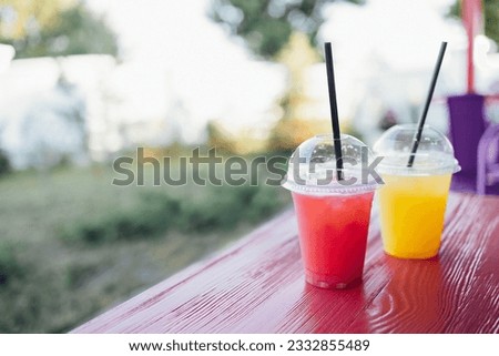 Image, Stock Photo two plastic cups with liquor stand on a wooden table