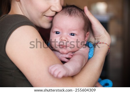 One month old baby boy in the arms of her mother