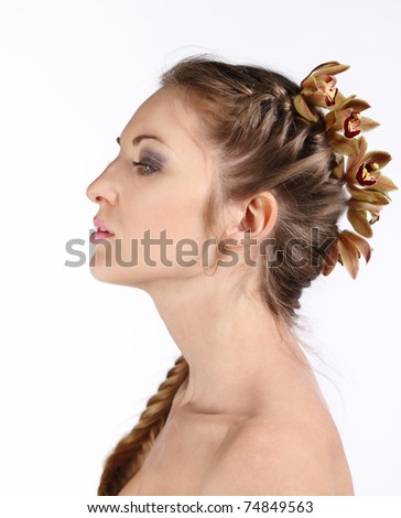 Portrait of the beautiful young blond girl with orchid in her hair