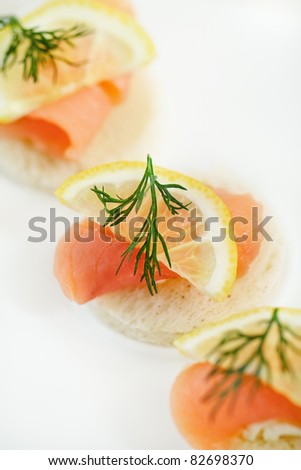 Extreme close-up of smoked salmon served with lemon, cheese and dill