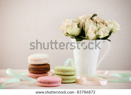 French macaroons on the table decorated with ribbons and roses