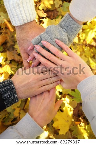 Hands of best friends together outdoor. Autumn