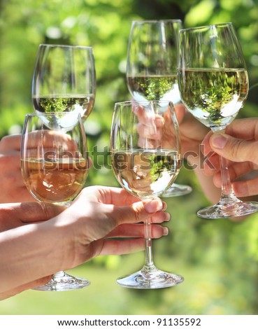 Celebration. People holding glasses of white wine making a toast