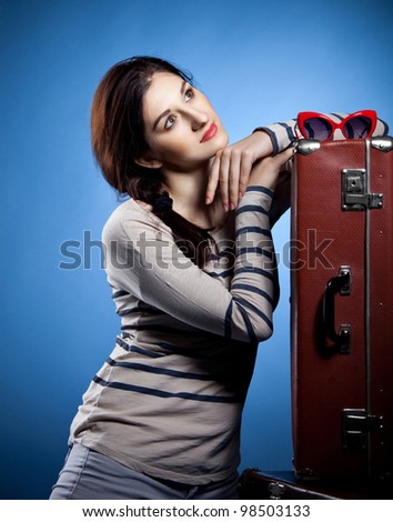 Portrait of the lovely woman with suitcases in retro style