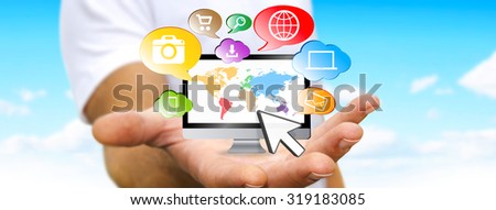 Young man holding computer in his hand surrounded by icons
