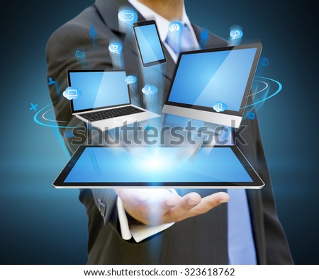 Businessman with computer phone and tablet in his hand