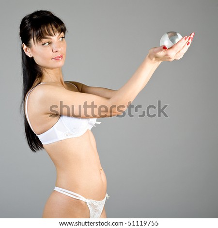 young woman in white linen with a silver sphere