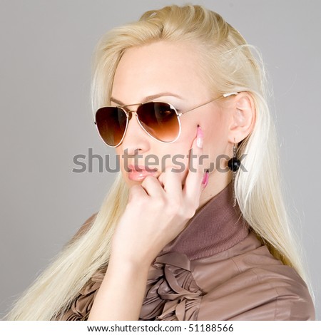 young beautiful girl in a brown blouse and sun glasses