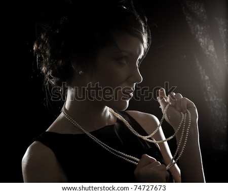 Retro a portrait of the beautiful brunette against a dark background