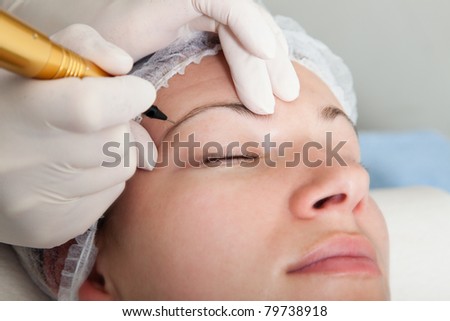 Cosmetologist making permanent makeup