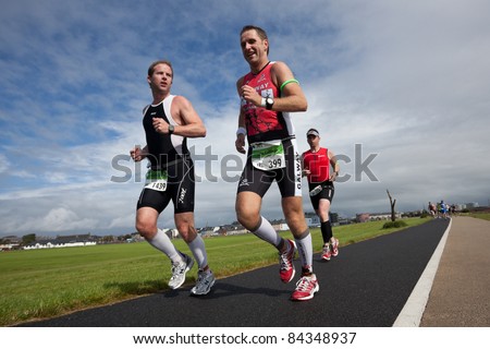 GALWAY, IRELAND - SEPT 4: John Cullinan (399) and Gavin Mcallister (1439) compete at first Edition of Iron Man  Triathlon on September 4, 2011 in Galway, Ireland