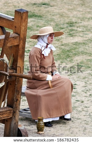 LONDON, UK - JULY 28, 2010: Actress in a medieval suit plays a scene from the historical past. The picture was taken in one of the courtyards of the Tower of London