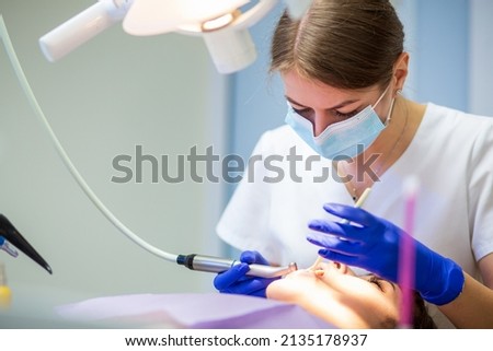 Dentist woman doctor working with patient in professionally equipped stomatologic cabinet  Stockfoto © 