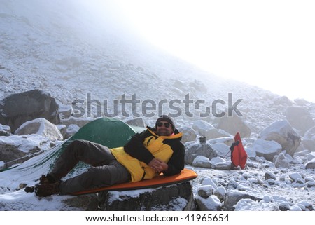 Man is resting in the mountaineering camp in misty morning