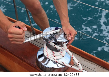 men\'s hands pull the rope by a winch