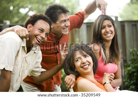 Interracial family making silly gestures posing for photograph