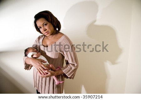 Mother with serious expression holding newborn