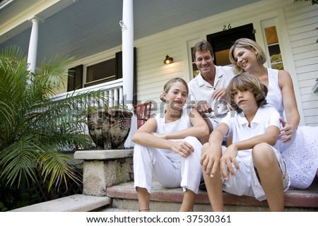 Family sitting together on front porch steps