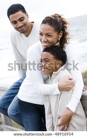 Ten year old African-American boy with parents at beach