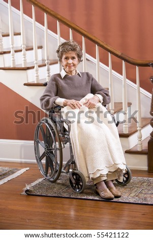 Elderly woman in 70s at home sitting in wheelchair