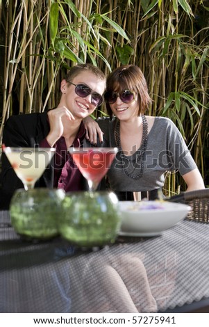Young romantic couple having cocktails on patio