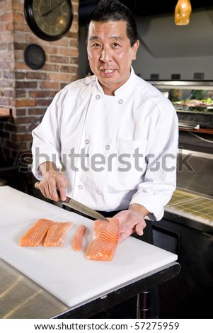 Japanese chef in restaurant slicing raw fish for salmon sushi