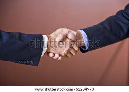 Close up of business handshake, sleeves of men wearing suits