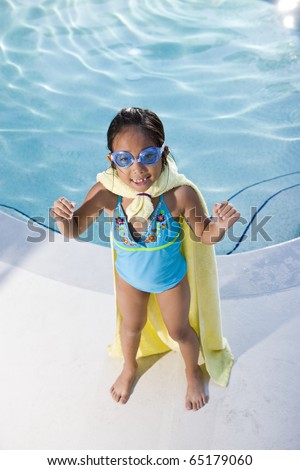 Girl, 7 years, playing by swimming pool in pretend superhero costume
