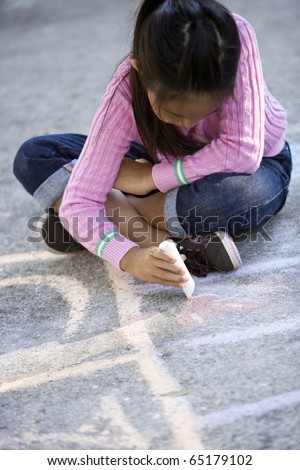 Asian girl, 7 years, playing outdoors, drawing pictures with sidewalk chalk