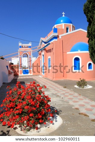 Colorful orthodox church with typical architecture and blue dome in Oia, Santorini island, Greece
