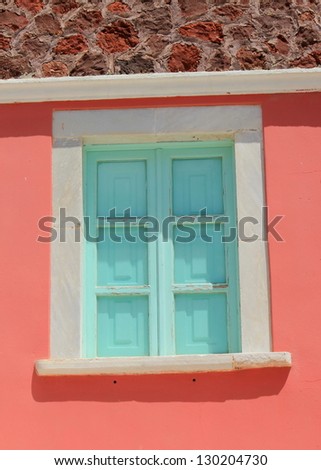 Green shutters closed on colorful home facade in Santorini, Greece