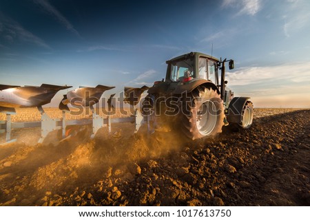 Tractor plowing fields -preparing land for sowing 商業照片 © 
