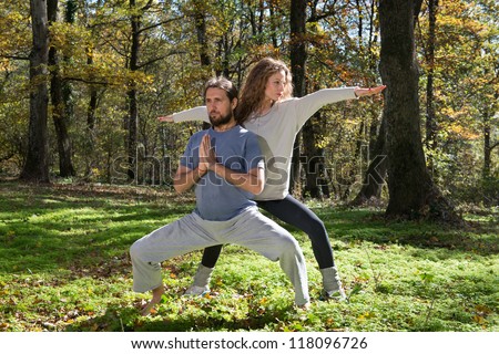 girl and man doing yoga meditation in a forest