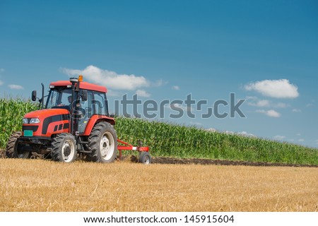 Tractor plowing the stubble field