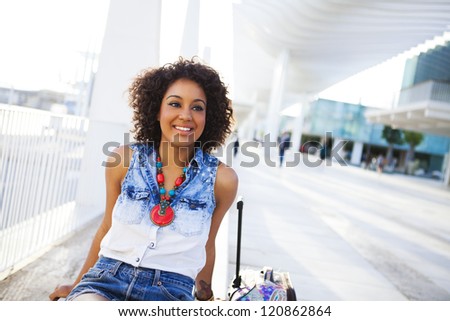 Portrait of a young black woman, fashion model wearing short jeans with afro hairstyle in train station