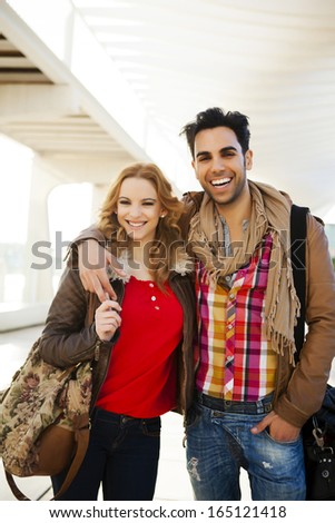 Young couple in a candid shot. They are walking in the street.