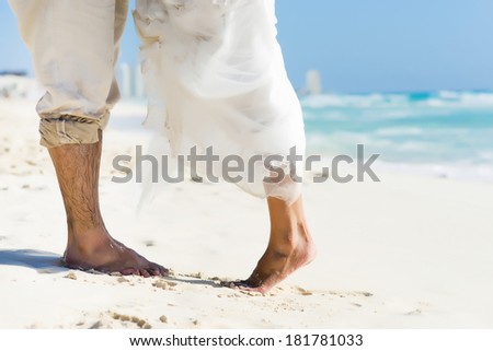 Wedding at the beach. Closeup of feet raised for a kiss.