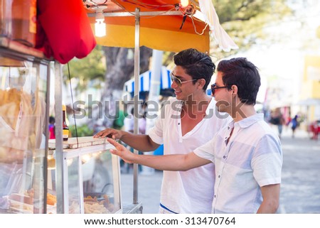 Couple traveling in latin america, buying street food in a truck. Isla Mujeres, Mexico.