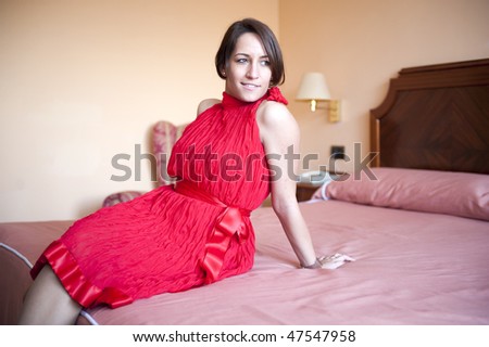 Young beautiful woman in party dress in her bedroom