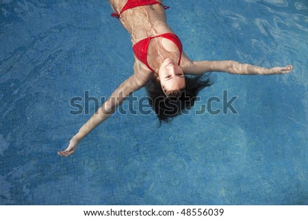 Beautiful woman floating on swimming pool