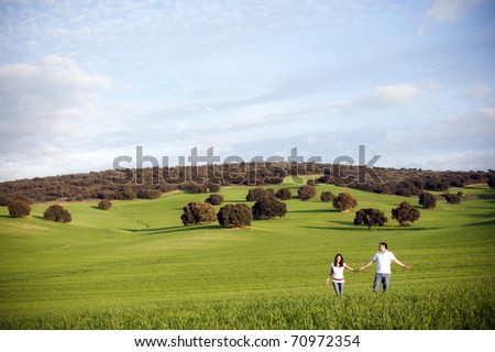 Young happy couple in green field