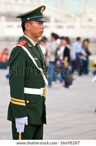 BEIJING - OCT. 20: Chinese Royal palace guard patrols the busy forbidden city entrance on Oct. 20, 2007 in Beijing with crowds of people entering to celebrate the start of their national holidays.