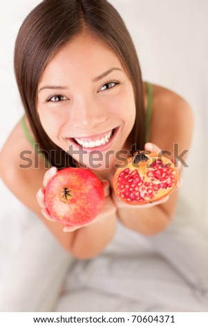 Pomegranate fruit. Woman showing pomegranate smiling.