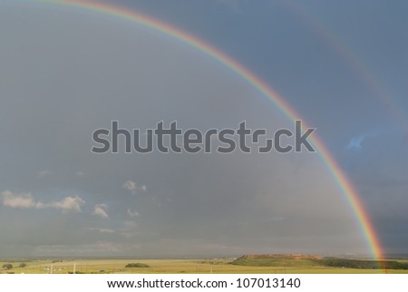 colorful rainbow in the storm sky over the field
