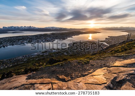 Tromso city in Tromsoya Island as seen from Mount Storsteinen under the Midnight Sun in Norway.