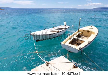 Motor boats drifting in the deep blue sea on Croatian coast.Adriatic Sea background.Crystal clear water,good sunny weather.Beautiful blue lagoon for summer vacation trip