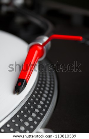 Professional DJ audio equipment - shperical turntable needle on white vinyl record